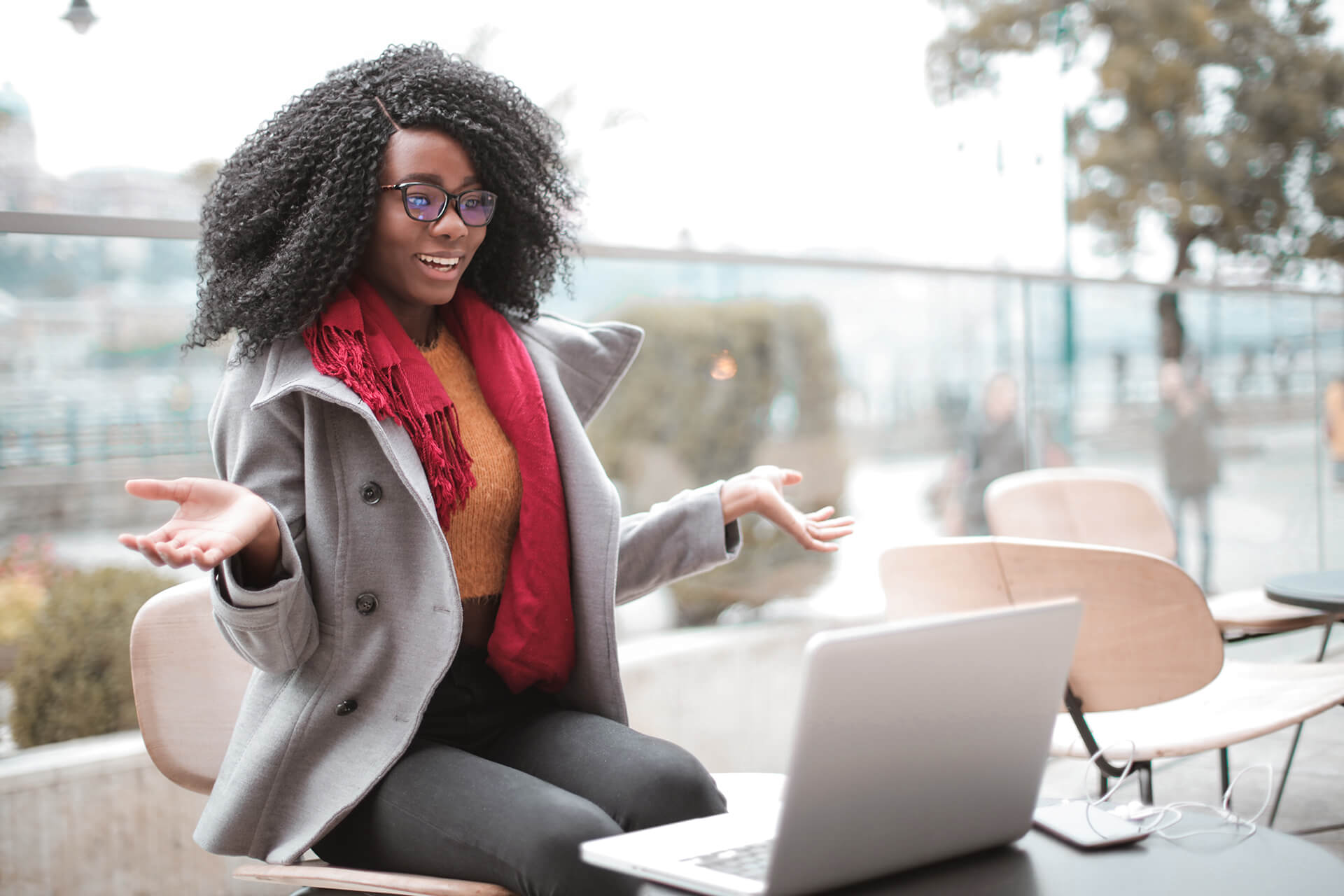 Woman sitting outside using online webcam chat software on laptop.